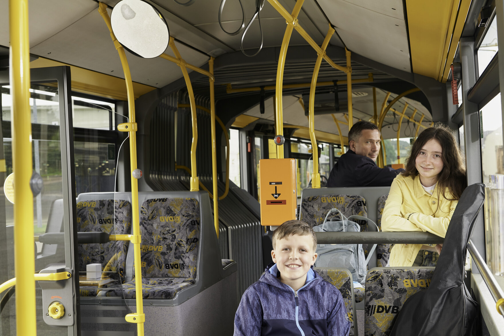 Minister Martin Dulig sitzt mit zwei Schülern in einem Bus
