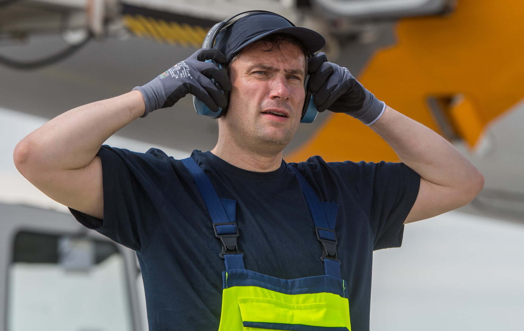 Minister Martin Dulig auf dem Flughafen mit Kopfhörern zum Arbeitsschutz