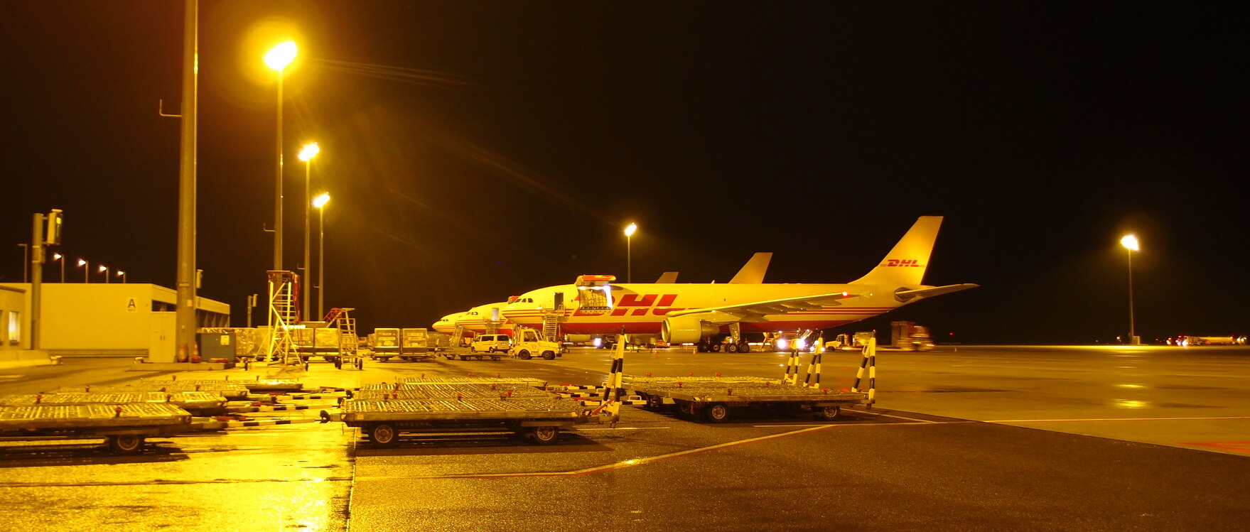 Drei Maschinen mit der Aufschrift "DHL" auf dem Flughafen.