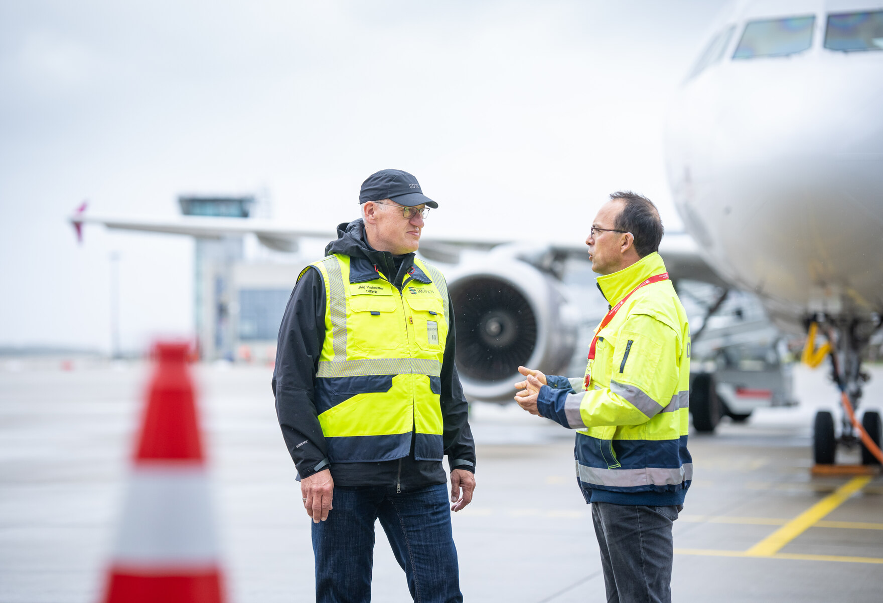 Steffen Mäder, Leiter Lärm- und Umweltschutz der Flughafen Leipzig/Halle GmbH spricht mit Jörg Puchmüller (Fluglärmschutzbeauftragter) auf dem Flughafen Dresden.