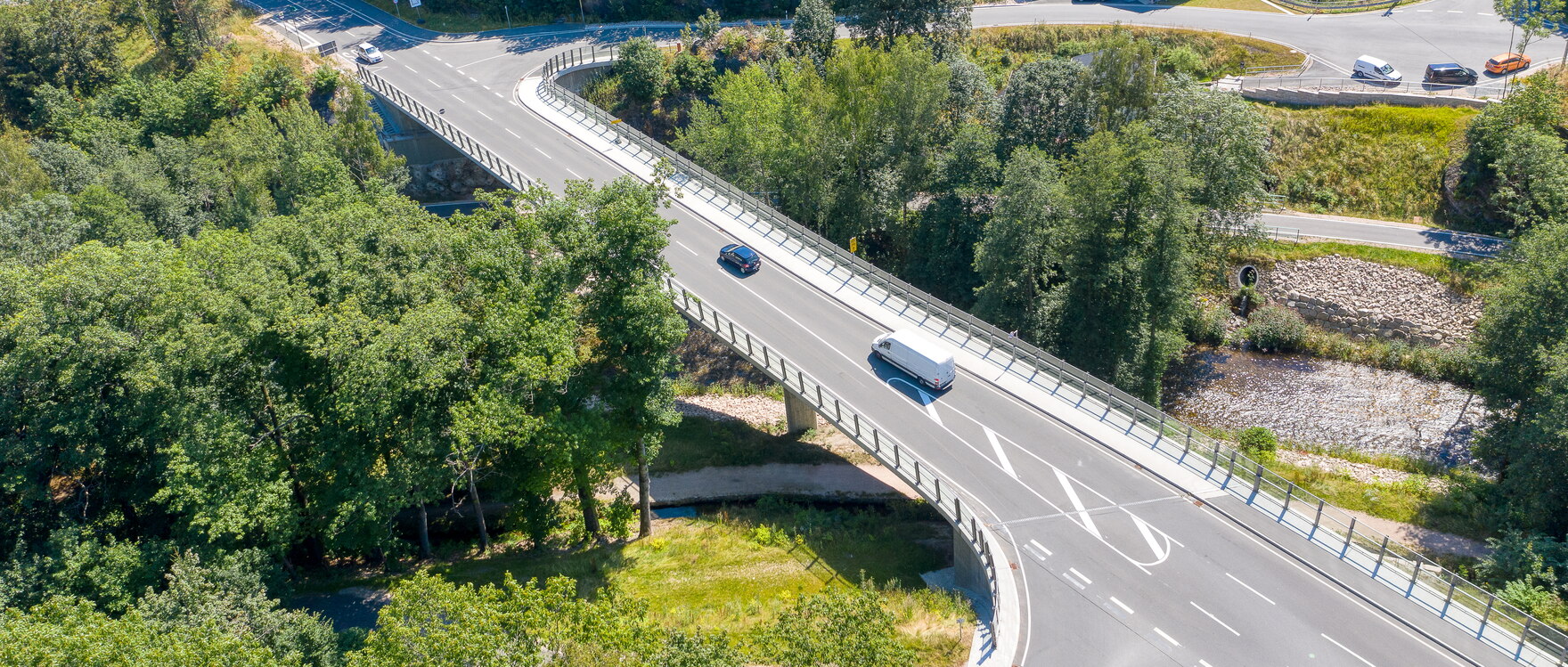 Eine Straße entlang von Bäumen und Häusern (Draufsicht).